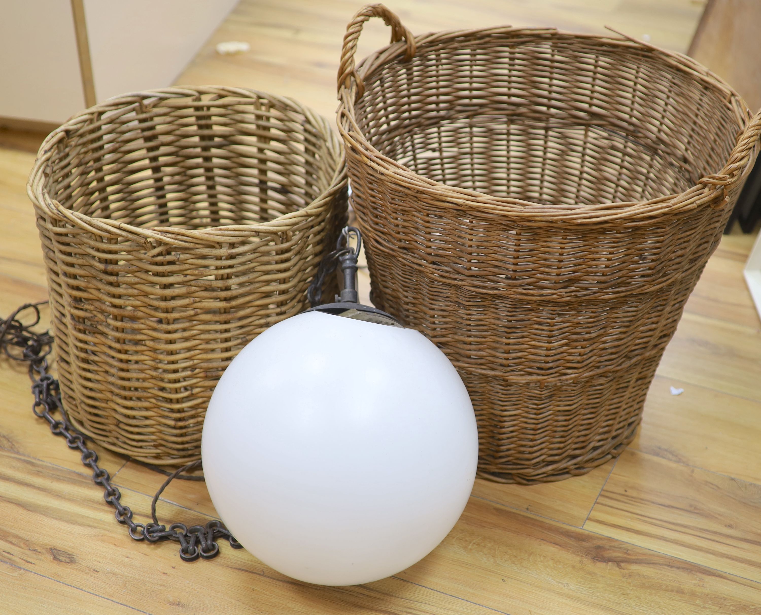 A glass hanging lamp and two wicker baskets